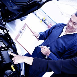 Due persone controllano il motore di un'auto.