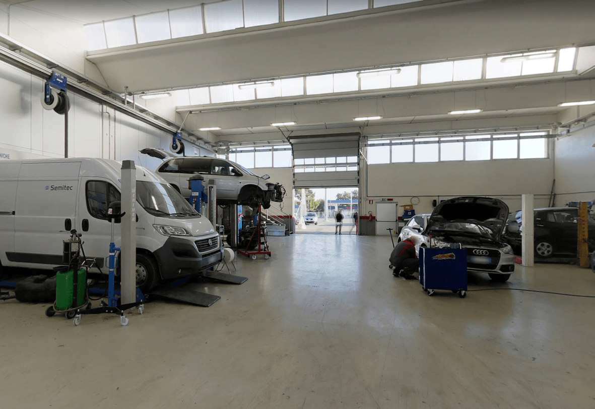 Officina meccanica con veicoli in riparazione.