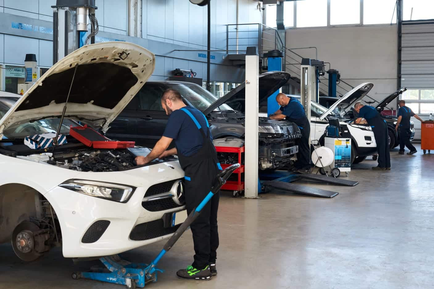 Meccanici lavorano su auto in un'officina.