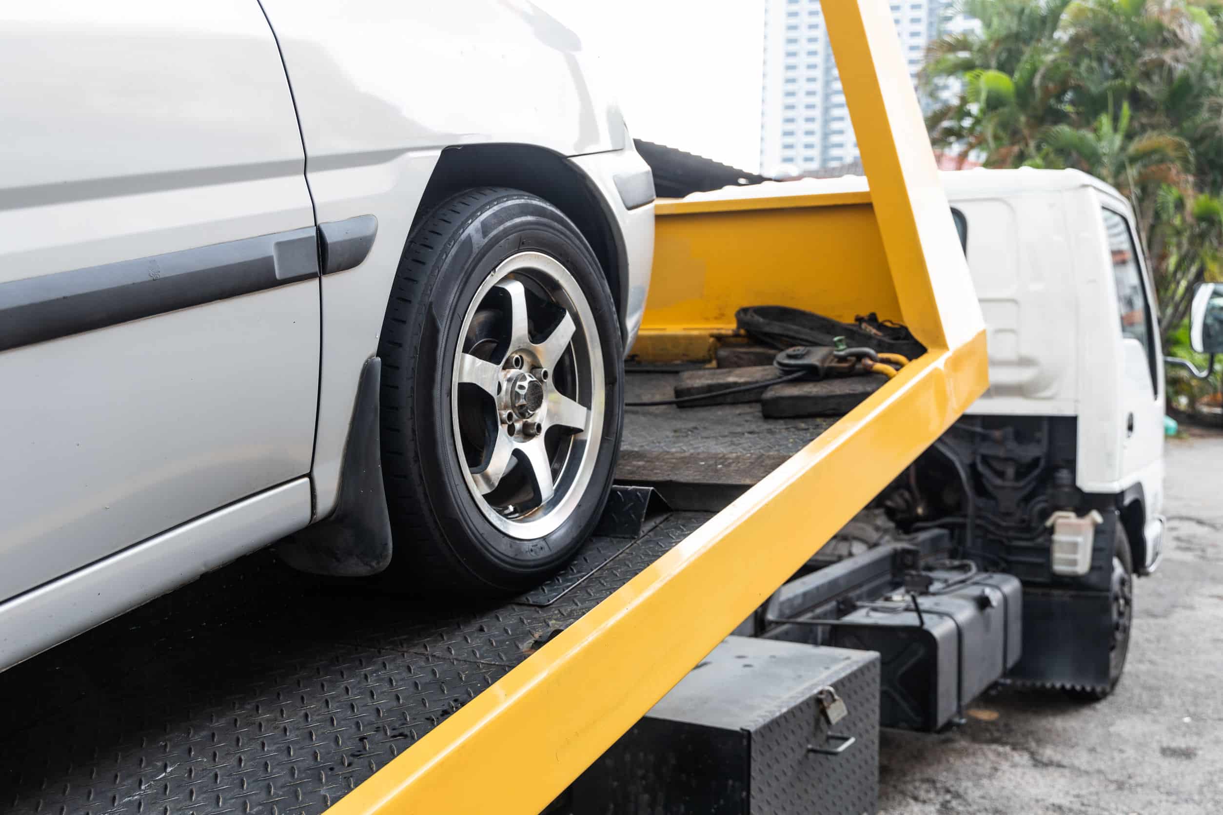 Auto bianca su carro attrezzi giallo.
